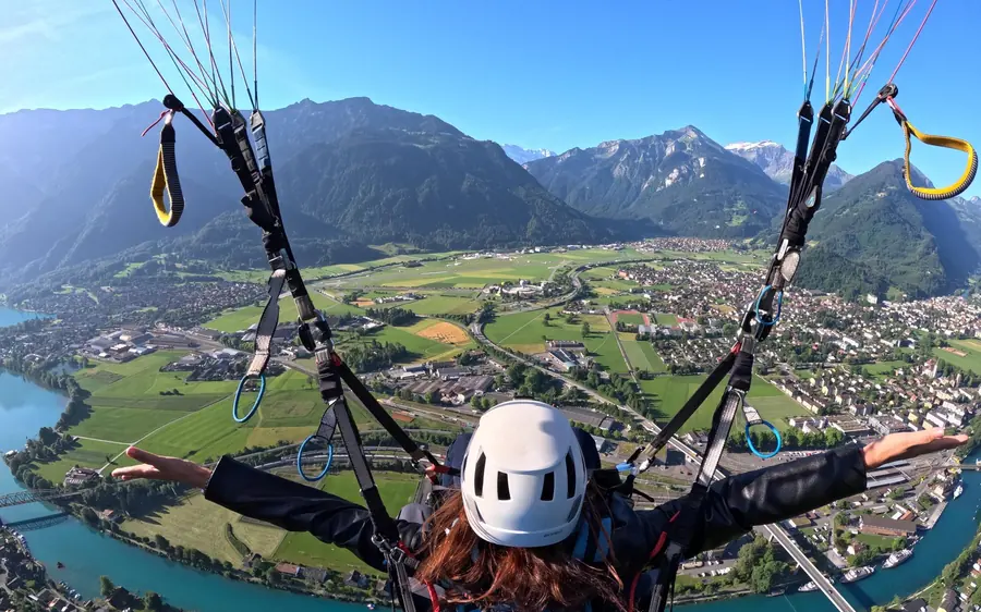 A paraglider wing against blue sky above the lakes of the Jungfrau region